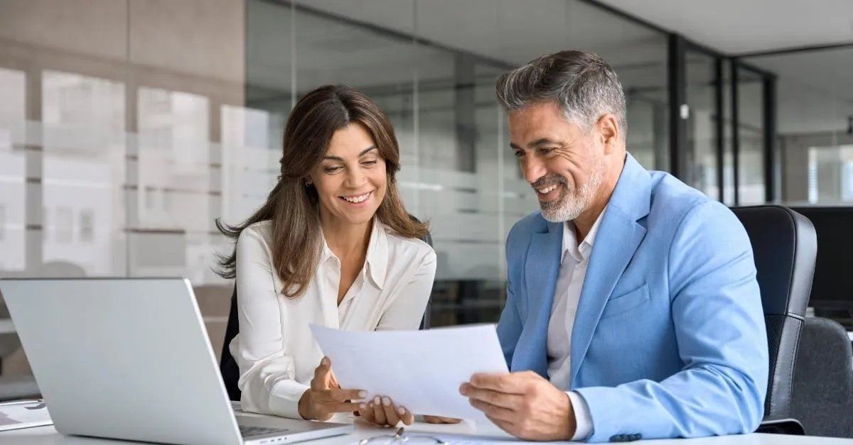 Two professionals reviewing a campaign document before approval